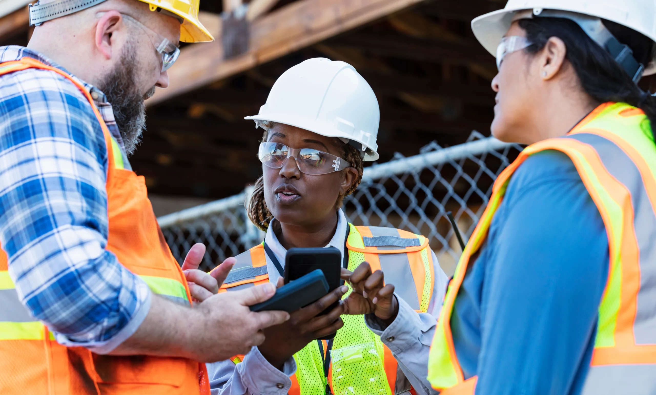 Three individuals engaged in a discussion, brainstorming strategies to enhance Behavioural Based Safety (BBS) and prevent workplace accidents.